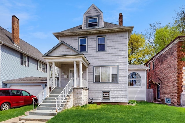traditional style home featuring covered porch, a garage, a front yard, a chimney, and a shingled roof