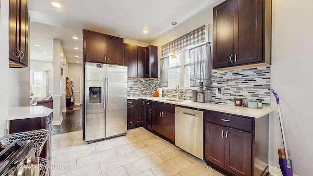 kitchen with stainless steel appliances, plenty of natural light, a sink, light countertops, and recessed lighting