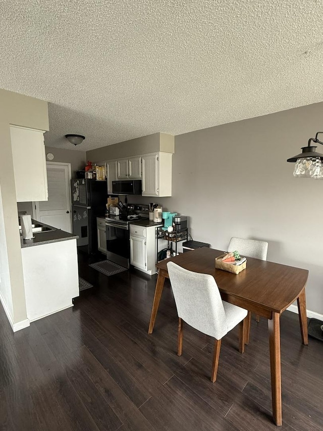 dining area with a textured ceiling and dark wood-style flooring