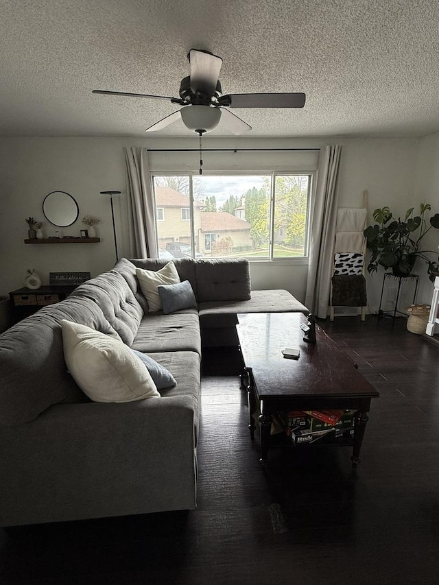 living room featuring a textured ceiling, ceiling fan, and wood finished floors
