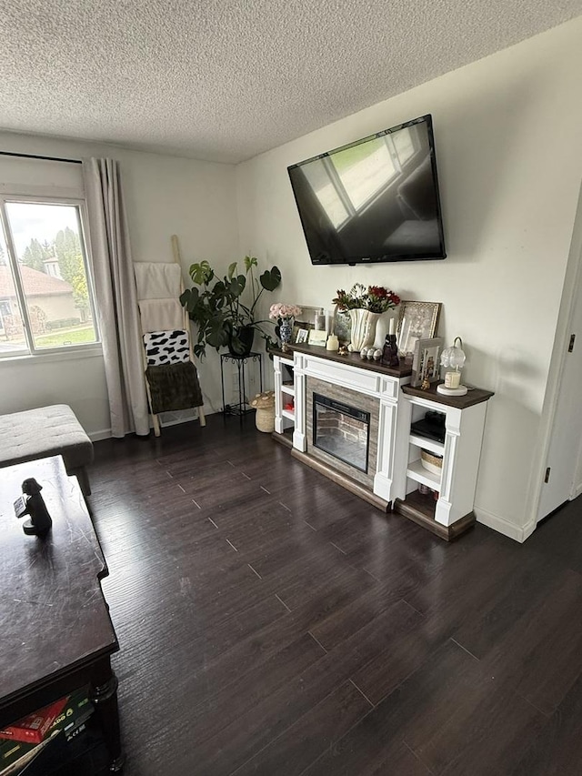 living area featuring baseboards, a textured ceiling, and dark wood-style flooring