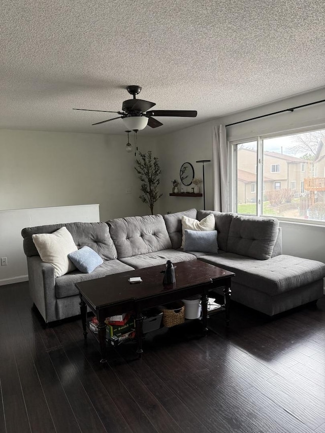 living room featuring a ceiling fan, dark wood finished floors, and a textured ceiling