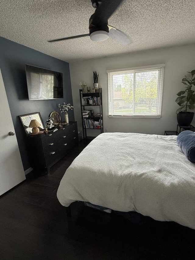 bedroom with a textured ceiling and wood finished floors