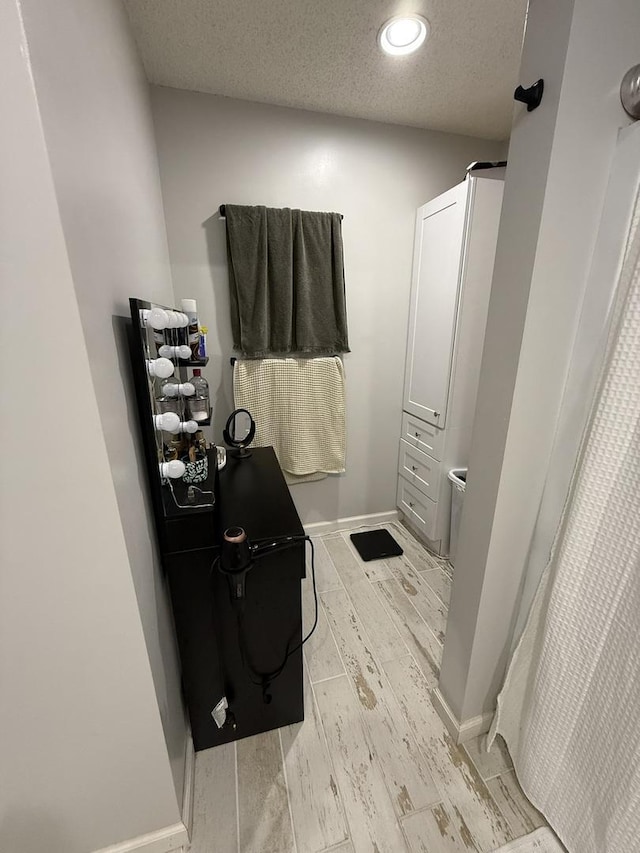 full bath with a textured ceiling, a shower with shower curtain, recessed lighting, baseboards, and wood finished floors