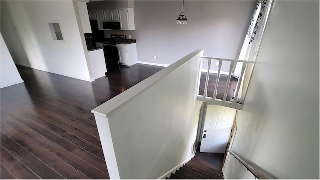 stairs featuring baseboards, electric panel, and wood finished floors