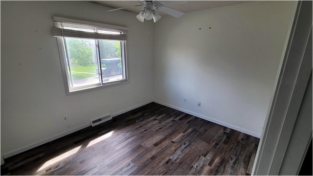 empty room featuring baseboards, a ceiling fan, visible vents, and dark wood finished floors