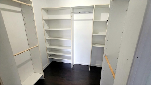 spacious closet with dark wood-style floors