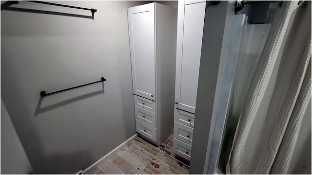 bathroom featuring baseboards and a shower with curtain