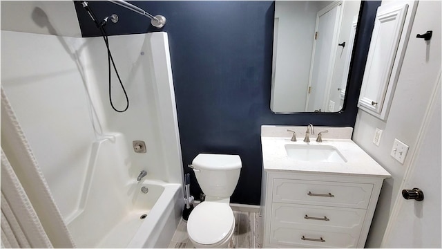 bathroom with toilet, baseboards,  shower combination, and vanity