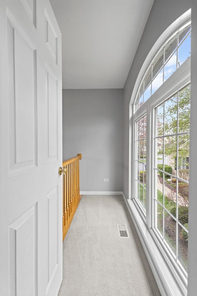 empty room with baseboards, visible vents, and carpet floors