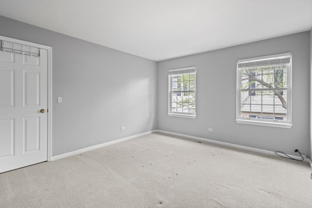 spare room featuring baseboards and carpet flooring