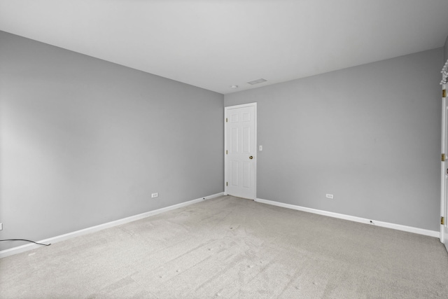 spare room with light carpet, visible vents, and baseboards