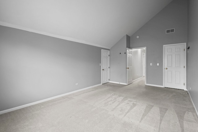 interior space featuring baseboards, visible vents, carpet flooring, and high vaulted ceiling