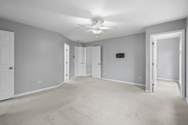 unfurnished bedroom with baseboards, a ceiling fan, and light colored carpet