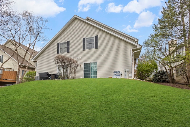 back of house featuring a lawn and central air condition unit