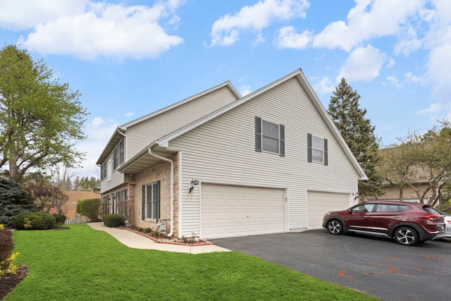 view of side of home featuring a garage, a lawn, brick siding, and aphalt driveway