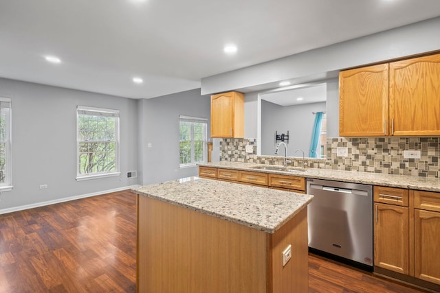kitchen featuring stainless steel dishwasher, tasteful backsplash, a sink, dark wood-type flooring, and a kitchen island