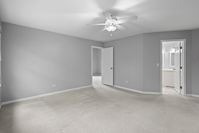 unfurnished bedroom with ceiling fan, ensuite bathroom, baseboards, and light colored carpet