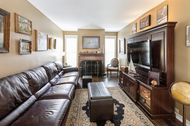 living area with dark wood finished floors and a fireplace