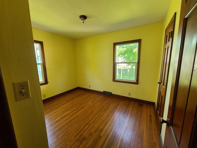 518 3rd Ave, Dixon, IL 61021 - unfurnished bedroom featuring dark wood-style floors, multiple windows, and baseboards