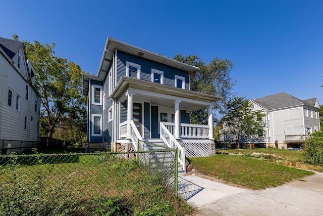 view of front of house with fence, stairs, covered porch, and a front yard