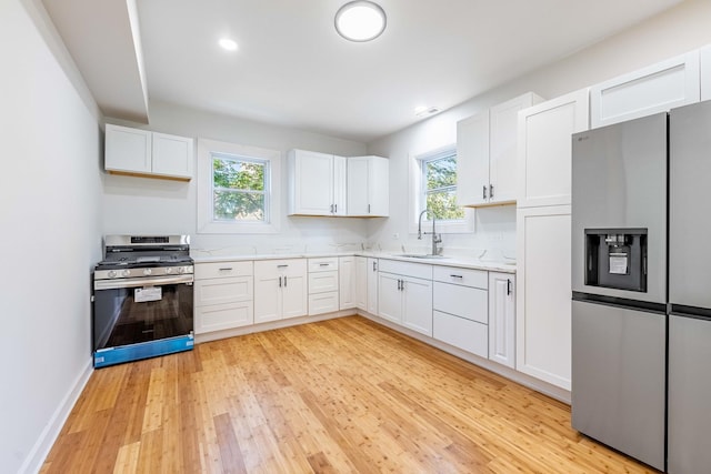 kitchen with light countertops, a healthy amount of sunlight, appliances with stainless steel finishes, and a sink
