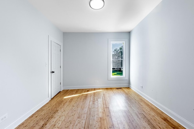 unfurnished room featuring baseboards and wood finished floors
