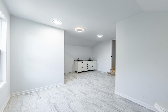 spare room with vaulted ceiling, baseboards, and recessed lighting