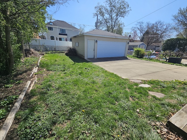 view of yard featuring a garage, fence, and an outbuilding