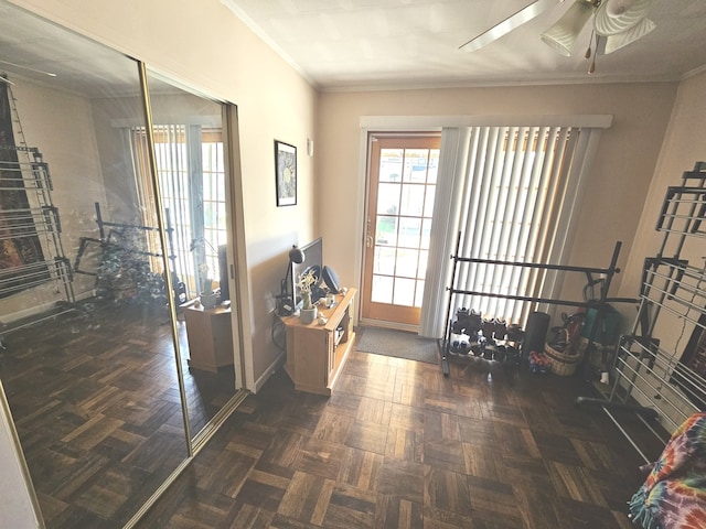 interior space featuring crown molding, baseboards, and ceiling fan