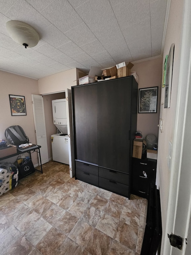 interior space featuring laundry area, stacked washer and dryer, and stone finish flooring