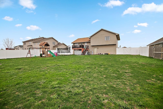 833 Poe St, Manteno, IL 60950 - view of yard with a trampoline, a fenced backyard, stairs, and a playground