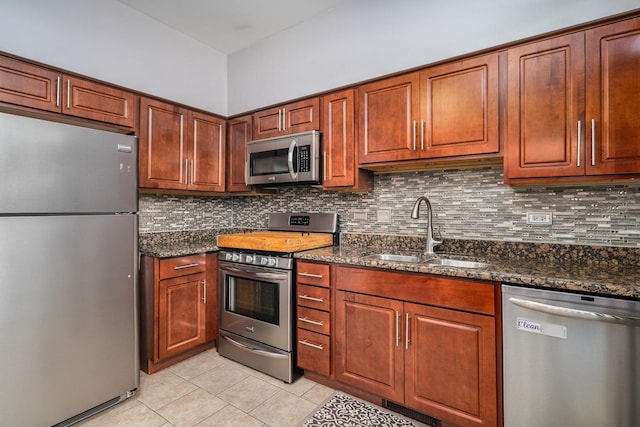 2743 River Bend Ln, Plainfield, IL 60586 - kitchen with stainless steel appliances, a sink, light tile patterned flooring, decorative backsplash, and dark stone counters