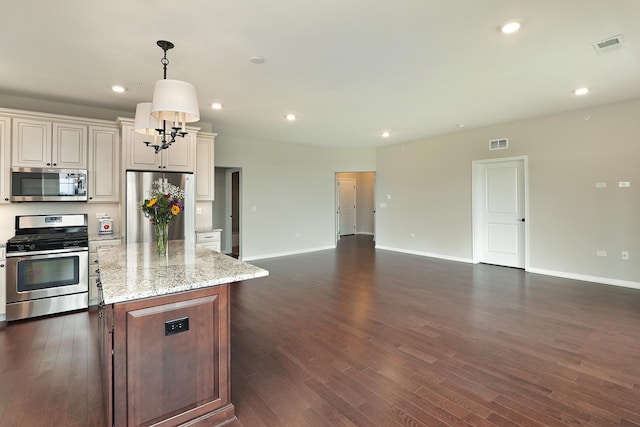 2701 Commons Dr Unit 409, Glenview, IL 60026 - kitchen featuring stainless steel appliances, open floor plan, a kitchen island, dark wood finished floors, and baseboards