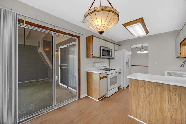 329 Pembroke Ct Unit 5, Schaumburg, IL 60193 - kitchen featuring white appliances, a sink, light wood-style flooring, light countertops, and pendant lighting
