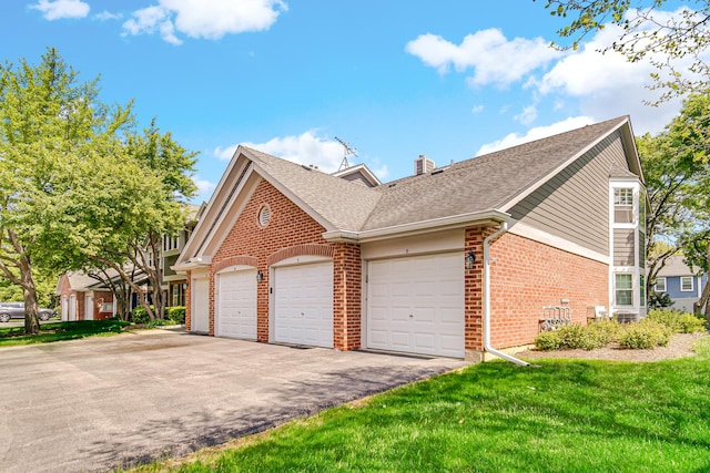 329 Pembroke Ct Unit 5, Schaumburg, IL 60193 - view of property exterior with brick siding, a shingled roof, a chimney, driveway, and a garage