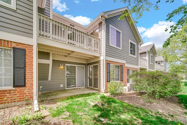 329 Pembroke Ct Unit 5, Schaumburg, IL 60193 - rear view of property featuring a balcony, brick siding, and a patio
