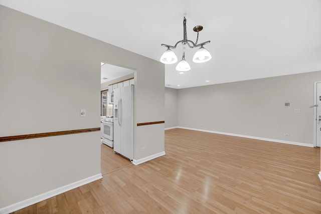 329 Pembroke Ct Unit 5, Schaumburg, IL 60193 - empty room with light wood-style floors, a chandelier, and baseboards