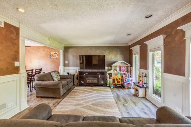 912 Macgregor Rd, Lockport, IL 60441 - living room with a textured ceiling, crown molding, wood finished floors, a wainscoted wall, and decorative columns