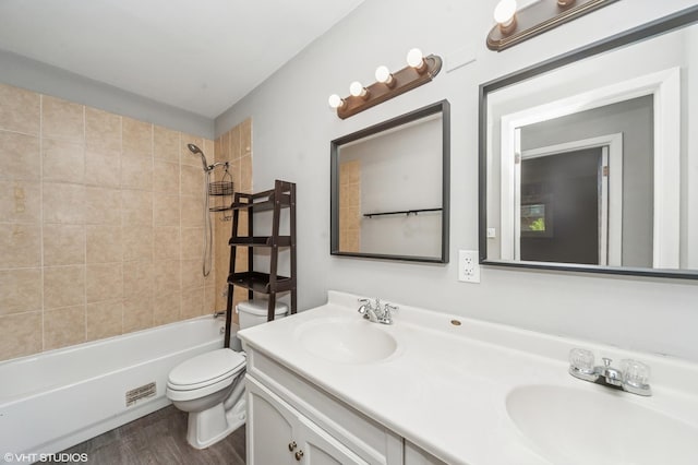 full bathroom with toilet, wood finished floors, double vanity, and bathtub / shower combination