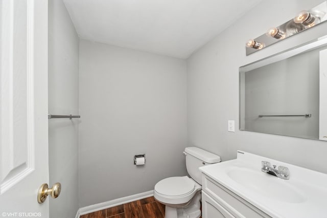 bathroom featuring wood finished floors, vanity, toilet, and baseboards
