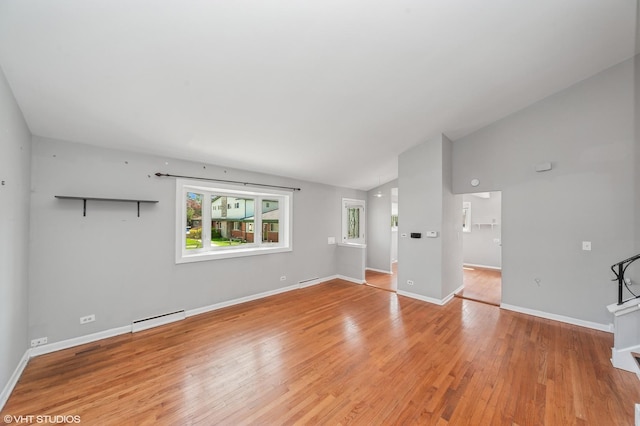unfurnished living room featuring a baseboard radiator, light wood-style floors, lofted ceiling, and baseboards