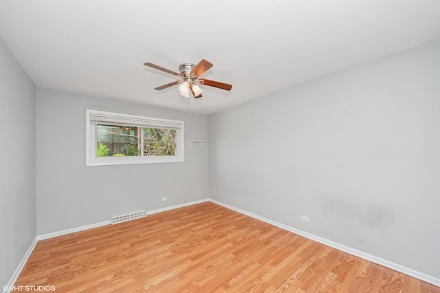 empty room with a ceiling fan, light wood-type flooring, and baseboards