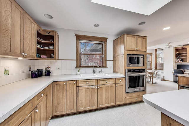 kitchen featuring decorative backsplash, a wealth of natural light, a sink, and appliances with stainless steel finishes