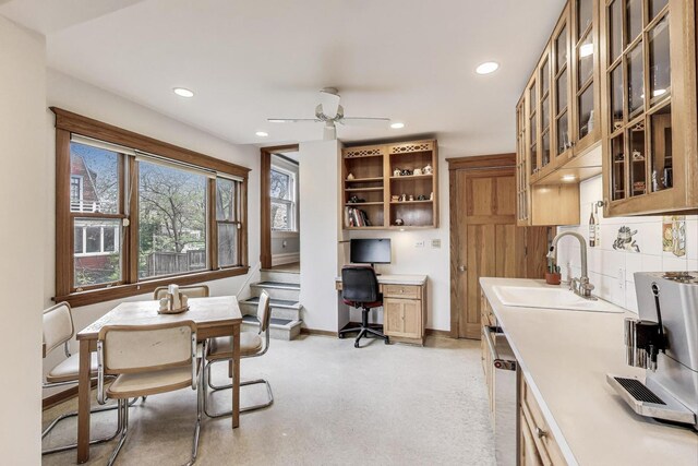 kitchen with ceiling fan, stainless steel dishwasher, a sink, and light countertops