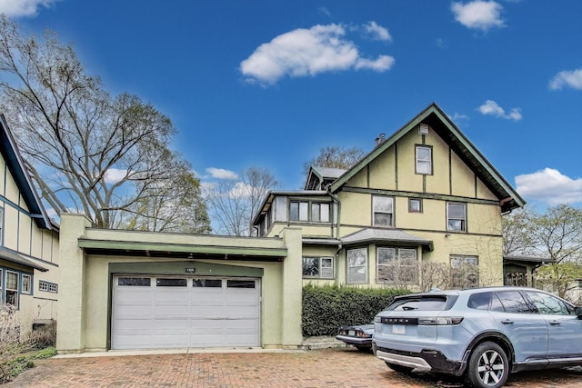 view of front of home with stucco siding, an attached garage, and decorative driveway