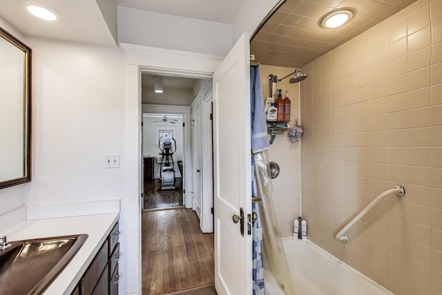 bathroom featuring a ceiling fan, vanity, wood finished floors, and shower / bath combo with shower curtain