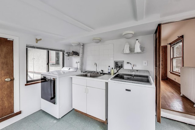 laundry area featuring cabinet space, a healthy amount of sunlight, a sink, and independent washer and dryer