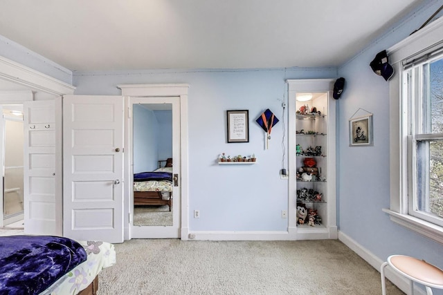 carpeted bedroom featuring baseboards and multiple windows