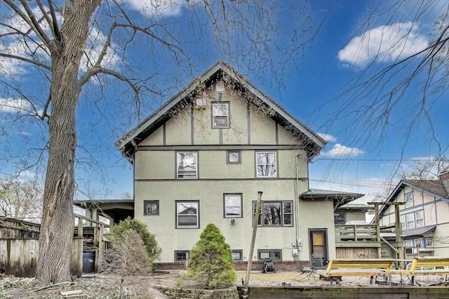 rear view of house featuring stucco siding